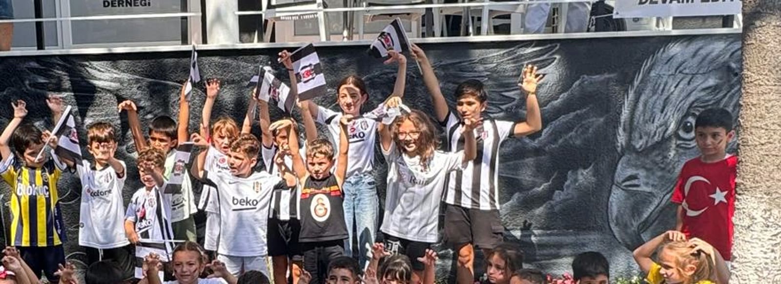 Dernek bahçesinin duvarındaki dev kartal grafitisi ve siyah beyaz damalı merdiven